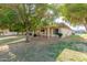 Beautiful backyard featuring a covered patio, mature trees, and well-maintained landscaping, ideal for outdoor enjoyment at 10425 W Desert Forest Cir, Sun City, AZ 85351