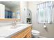 Bathroom features a neutral-colored vanity, toilet, and shower with a window for natural light at 10425 W Desert Forest Cir, Sun City, AZ 85351