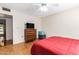 Bedroom with laminate floors, ceiling fan, and window with TV and closet at 10425 W Desert Forest Cir, Sun City, AZ 85351