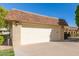 Exterior shot of a two-car garage with a brick facade, a well-maintained driveway, and manicured landscaping at 10425 W Desert Forest Cir, Sun City, AZ 85351