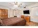 A bedroom with ample storage, closet space and a television with light wood flooring at 10425 W Desert Forest Cir, Sun City, AZ 85351