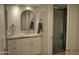 Elegant bathroom with marble countertops, white cabinetry, and a modern rounded mirror at 10444 N 69Th St # 128, Paradise Valley, AZ 85253