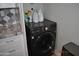Modern laundry area with front-load washer and dryer, plus storage for cleaning supplies at 10444 N 69Th St # 128, Paradise Valley, AZ 85253