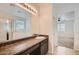 Bathroom featuring long vanity with granite counters, framed mirror and walk-in shower at 10528 W Crown King Rd, Tolleson, AZ 85353