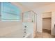 Bright bathroom with tub, glass-enclosed shower, and large window at 10528 W Crown King Rd, Tolleson, AZ 85353