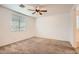 Neutral bedroom featuring carpet, a ceiling fan, and a bright window at 10528 W Crown King Rd, Tolleson, AZ 85353