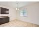 Cozy dining area featuring tile flooring, contemporary light fixture and a bright window at 10528 W Crown King Rd, Tolleson, AZ 85353