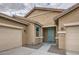 Inviting single-story home with a blue door and trim, a well-maintained lawn and a two-car garage at 10528 W Crown King Rd, Tolleson, AZ 85353