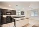 Modern kitchen with dark appliances, island seating, and ample counter space at 10528 W Crown King Rd, Tolleson, AZ 85353