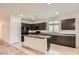 Well-equipped kitchen with dark cabinetry, granite countertops, and an island with bar seating at 10528 W Crown King Rd, Tolleson, AZ 85353