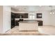 Well-lit kitchen with tile floors, island, dark wood cabinets and black appliances at 10528 W Crown King Rd, Tolleson, AZ 85353