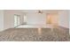 Bright, open living room featuring neutral carpet, ceiling fan, and sliding glass doors at 10528 W Crown King Rd, Tolleson, AZ 85353