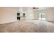 Open-concept living room with carpeted floors, a ceiling fan, and access to the kitchen at 10528 W Crown King Rd, Tolleson, AZ 85353