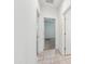 Hallway featuring ceramic tile flooring and open doorways to the bedrooms at 10961 W Taylor St, Avondale, AZ 85323