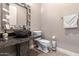 Chic half bathroom features a modern stone sink and decorative mirror at 11054 E North Ln, Scottsdale, AZ 85259