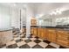 Modern bathroom features a black and white checkered floor, granite countertops, and glass enclosed shower at 11054 E North Ln, Scottsdale, AZ 85259