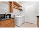 Functional laundry room with a wooden shelf, front-load washer and dryer, plus a utility sink at 11054 E North Ln, Scottsdale, AZ 85259