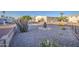 Wide view of the gravel-covered backyard featuring desert plants and mature shade trees at 112 S 72Nd Way, Mesa, AZ 85208