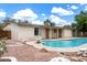 Backyard featuring a swimming pool, covered patio, rock landscaping, and mature trees at 1159 W Emelita Ave, Mesa, AZ 85210