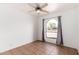 Cozy bedroom with a ceiling fan, and a large window with dark curtains at 1159 W Emelita Ave, Mesa, AZ 85210