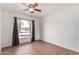 Bright bedroom showcasing a ceiling fan, and a large window with curtains at 1159 W Emelita Ave, Mesa, AZ 85210