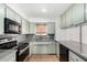Well-lit kitchen featuring granite countertops, ample cabinet space, and modern black appliances at 1159 W Emelita Ave, Mesa, AZ 85210