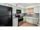 Updated kitchen with granite countertops, stainless steel oven, and black appliances at 1159 W Emelita Ave, Mesa, AZ 85210