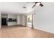 Bright living room featuring tile flooring, ceiling fan, and an adjacent kitchen with granite countertops at 1159 W Emelita Ave, Mesa, AZ 85210