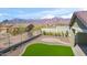 A fenced backyard has manicured artificial turf, mountain views, and neutral rock landscaping at 11910 E Amanda Rd, Gold Canyon, AZ 85118