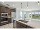 Kitchen area boasts stainless steel appliances, quartz countertops, and views of the adjacent dining area at 11910 E Amanda Rd, Gold Canyon, AZ 85118