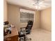 This carpeted bedroom features a ceiling fan, large window, and offers a comfortable workspace for working from home at 1347 E Vernoa St, San Tan Valley, AZ 85140