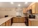 This kitchen features wooden cabinets, neutral countertops, black appliances and tile flooring at 1347 E Vernoa St, San Tan Valley, AZ 85140