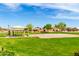 A well-maintained community playground with lush green grass and mature trees at 1347 E Vernoa St, San Tan Valley, AZ 85140