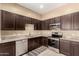 Well-lit kitchen with stainless steel appliances, granite countertops, and dark brown cabinets at 1367 S Country Club Dr # 1295, Mesa, AZ 85210