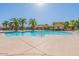 Resort-style pool area with palm trees, comfortable lounge chairs, and inviting waters at 1367 S Country Club Dr # 1295, Mesa, AZ 85210