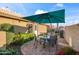 Backyard dining area under umbrella with garden space and BBQ setup, perfect for relaxing at 15149 W Vale Dr, Goodyear, AZ 85395