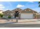 Attractive home with a two-car garage, desert landscape, and well-kept lawn on a sunny day at 15149 W Vale Dr, Goodyear, AZ 85395