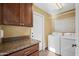 Functional laundry room with granite counters, cabinets, and modern washer and dryer at 15149 W Vale Dr, Goodyear, AZ 85395