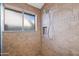 Modern shower features tiled walls, a niche for storage, and a window for natural light, offering a serene experience at 15149 W Vale Dr, Goodyear, AZ 85395