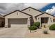 Charming one-story home features a neutral stucco exterior and a two-car garage at 15885 W Remington Dr, Surprise, AZ 85374