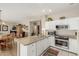 Open-concept kitchen features granite counters, white cabinetry and stainless steel appliances at 15885 W Remington Dr, Surprise, AZ 85374