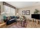 Comfortable living room features hardwood floors, a large window, and stylish furnishings at 15885 W Remington Dr, Surprise, AZ 85374