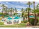 Inviting community pool area with lush palm trees, comfortable seating, and well-maintained landscaping at 15885 W Remington Dr, Surprise, AZ 85374