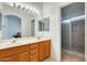 Bathroom featuring double sinks with a large mirror and a separate shower, providing convenience at 16034 W Carmen Dr, Surprise, AZ 85374