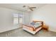 Comfortable bedroom with a ceiling fan, window, and carpet offers a tranquil retreat at 16034 W Carmen Dr, Surprise, AZ 85374