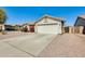 Charming single-story home featuring a two-car garage and low maintenance desert landscaping at 16034 W Carmen Dr, Surprise, AZ 85374