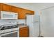 Kitchen featuring a white gas range, microwave, and wood cabinets for ample storage at 16034 W Carmen Dr, Surprise, AZ 85374