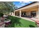 Backyard featuring a covered patio and lush green artificial grass with a view of fountain at 16769 W Brookhaven Ct, Surprise, AZ 85387