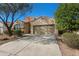 Inviting home with a two-car garage, desert landscaping, a large driveway, and lush desert trees at 18222 E La Posada Ct, Gold Canyon, AZ 85118