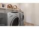 Convenient laundry room featuring front load washer and dryer with storage space at 18222 E La Posada Ct, Gold Canyon, AZ 85118